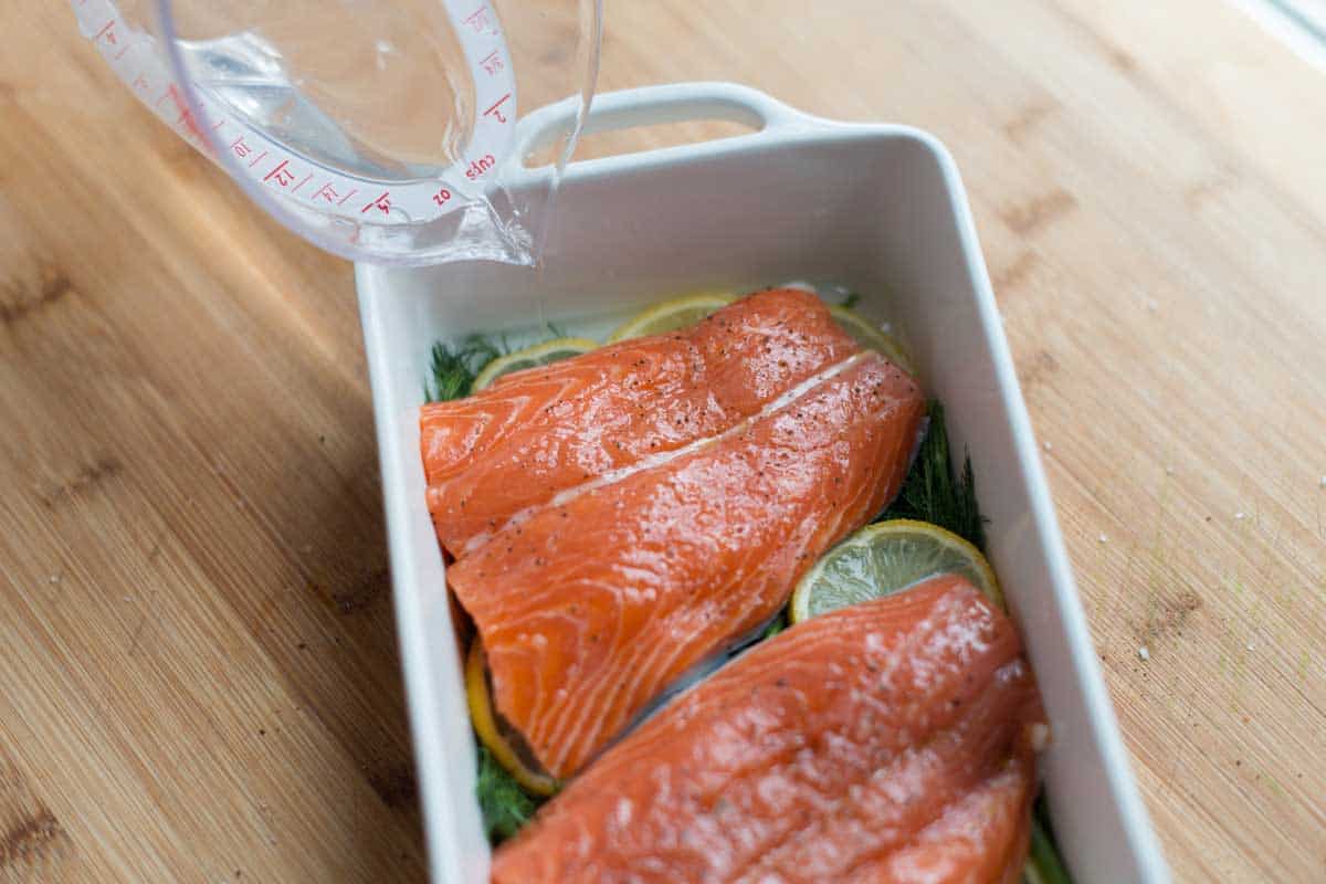 Adding a little liquid to the baking dish so the salmon gently poaches in the oven