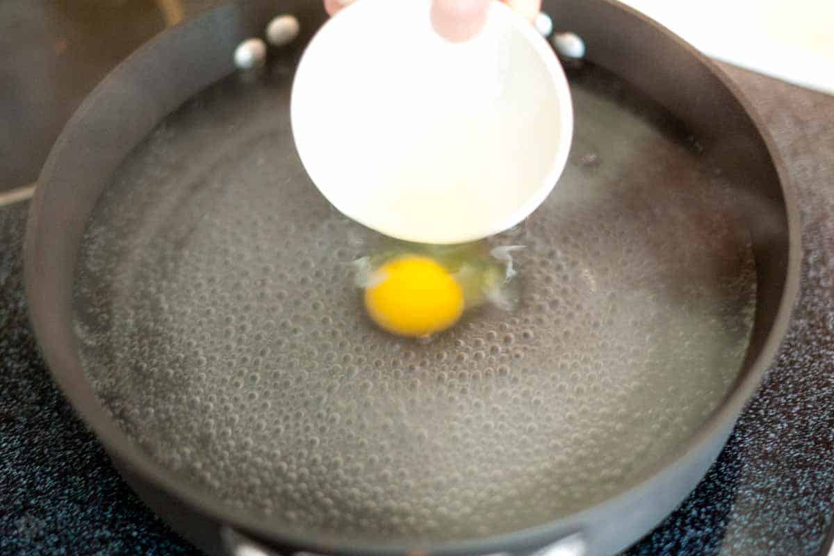 Crack egg into a small bowl then add to poaching water