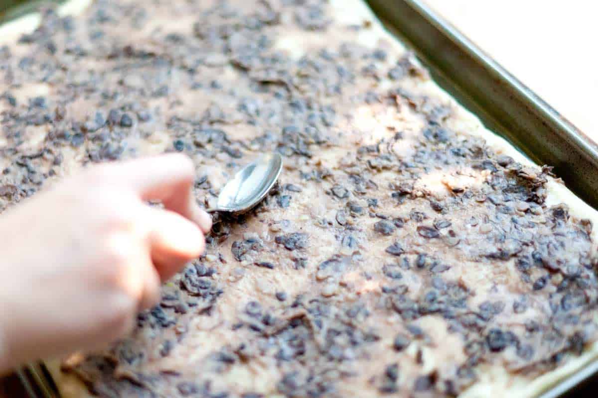 Easy Black Bean Pizza Topped with Salad Spreading the black beans
