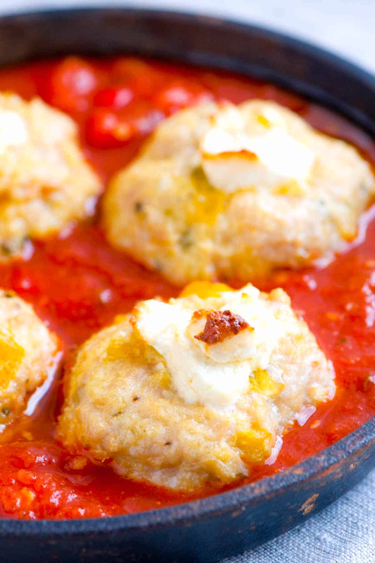 Cheese stuffed chicken meatballs on a bed of marinara sauce