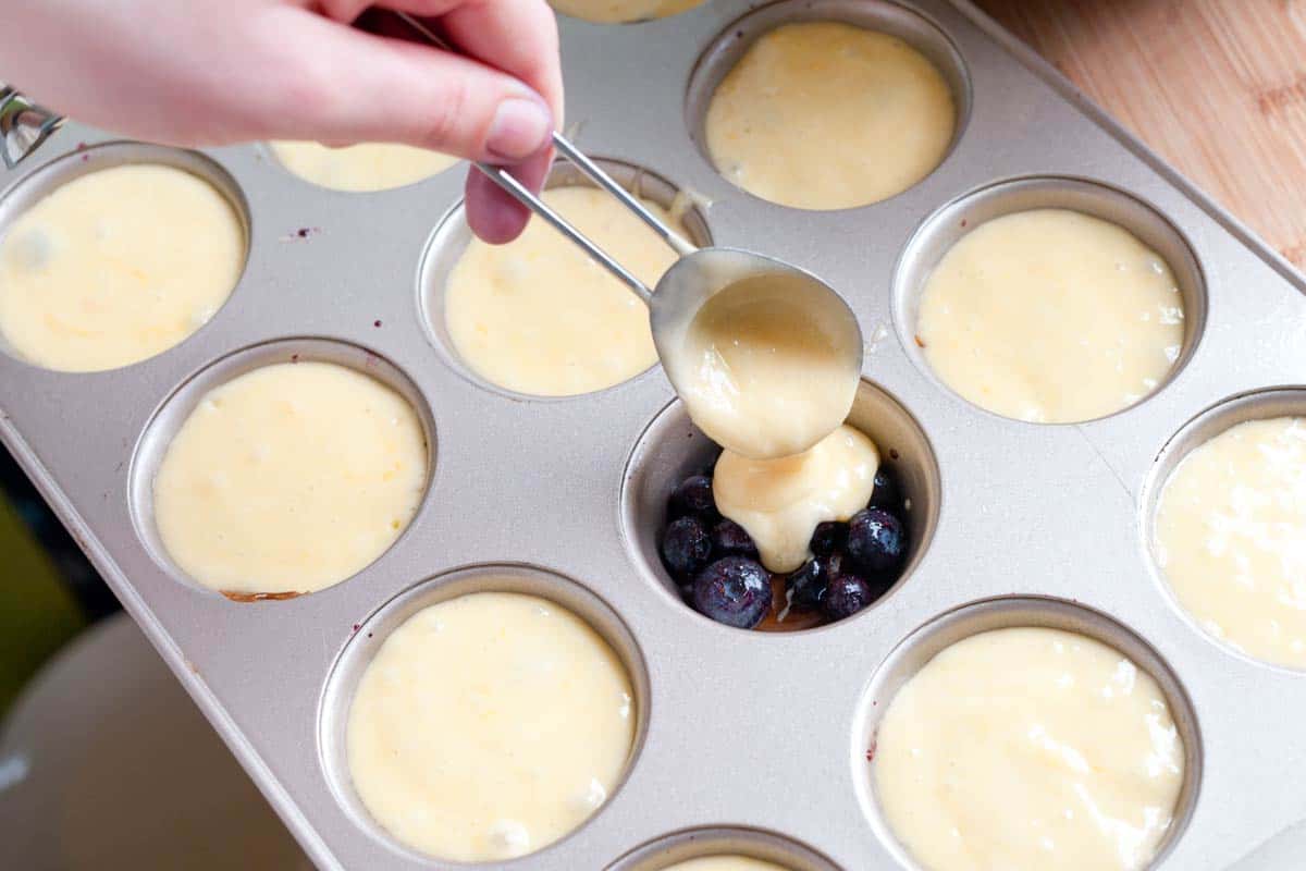Mini Upside Down Blueberry Cakes Filling the muffin cups