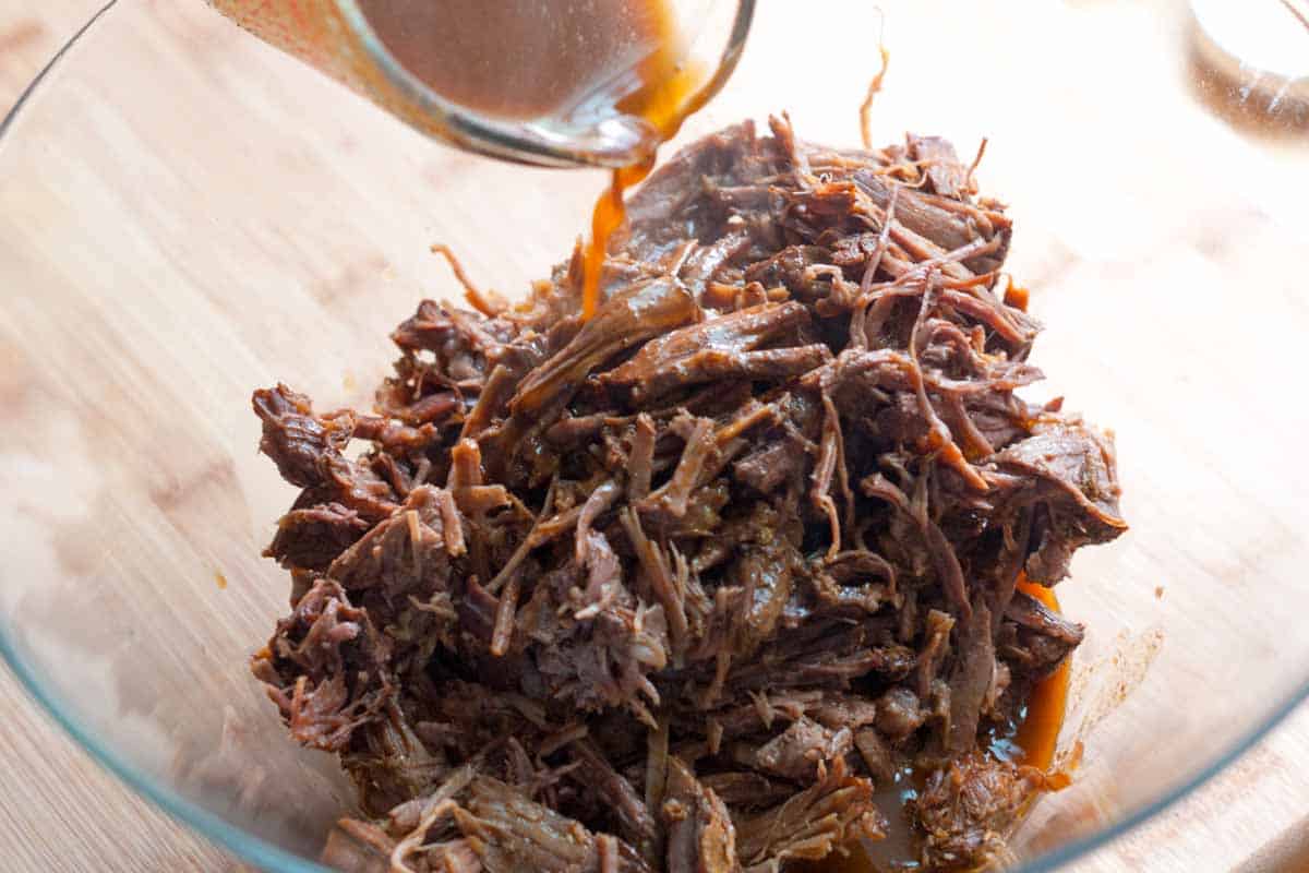 Toss cooking liquid with shredded beef