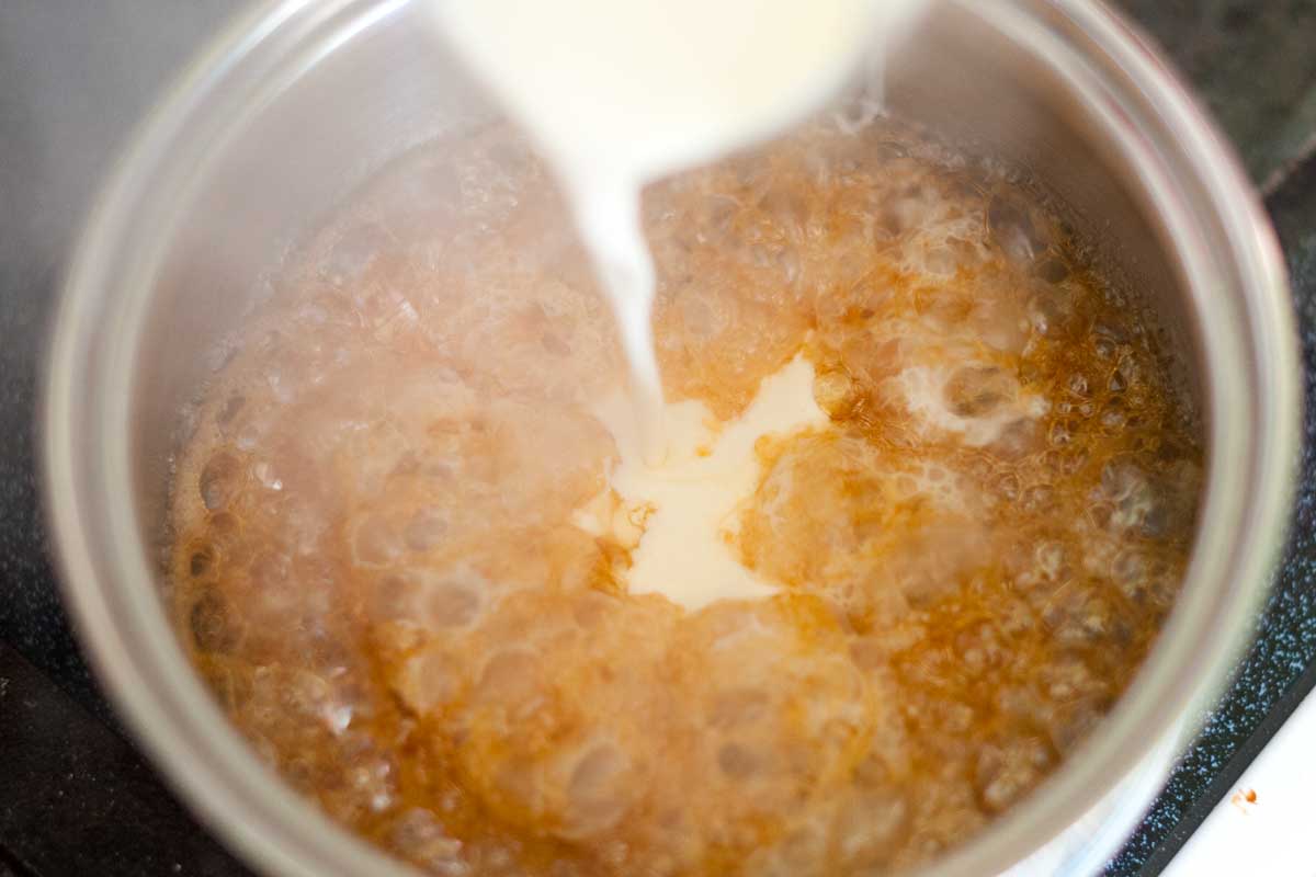 Making caramel sauce: Adding the cream to the sugar mixture