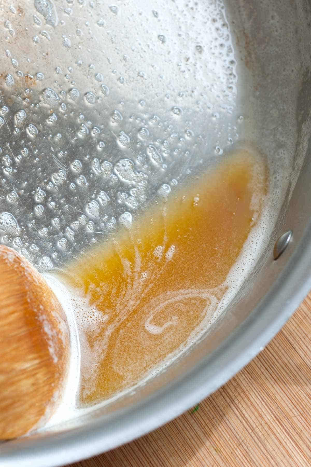 How to Brown Butter - Skillet with butter that has been browned to perfection. Brown butter looks light brown.