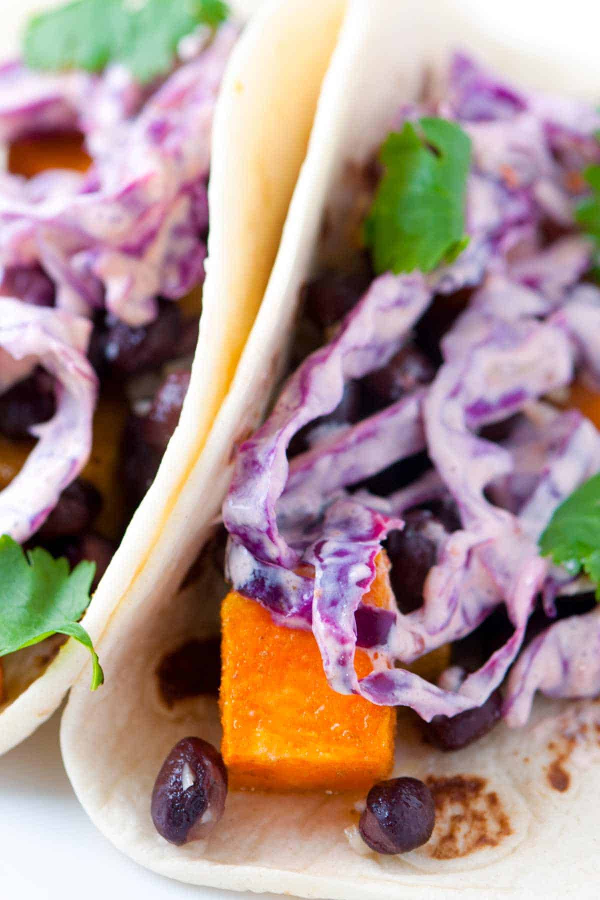 Roasted sweet potato and black bean tacos topped with a quick and easy chipotle slaw. Fast and healthy!