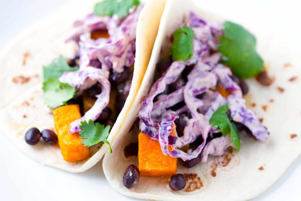 Roasted sweet potato and black bean tacos topped with a quick and easy chipotle slaw. Fast and healthy!