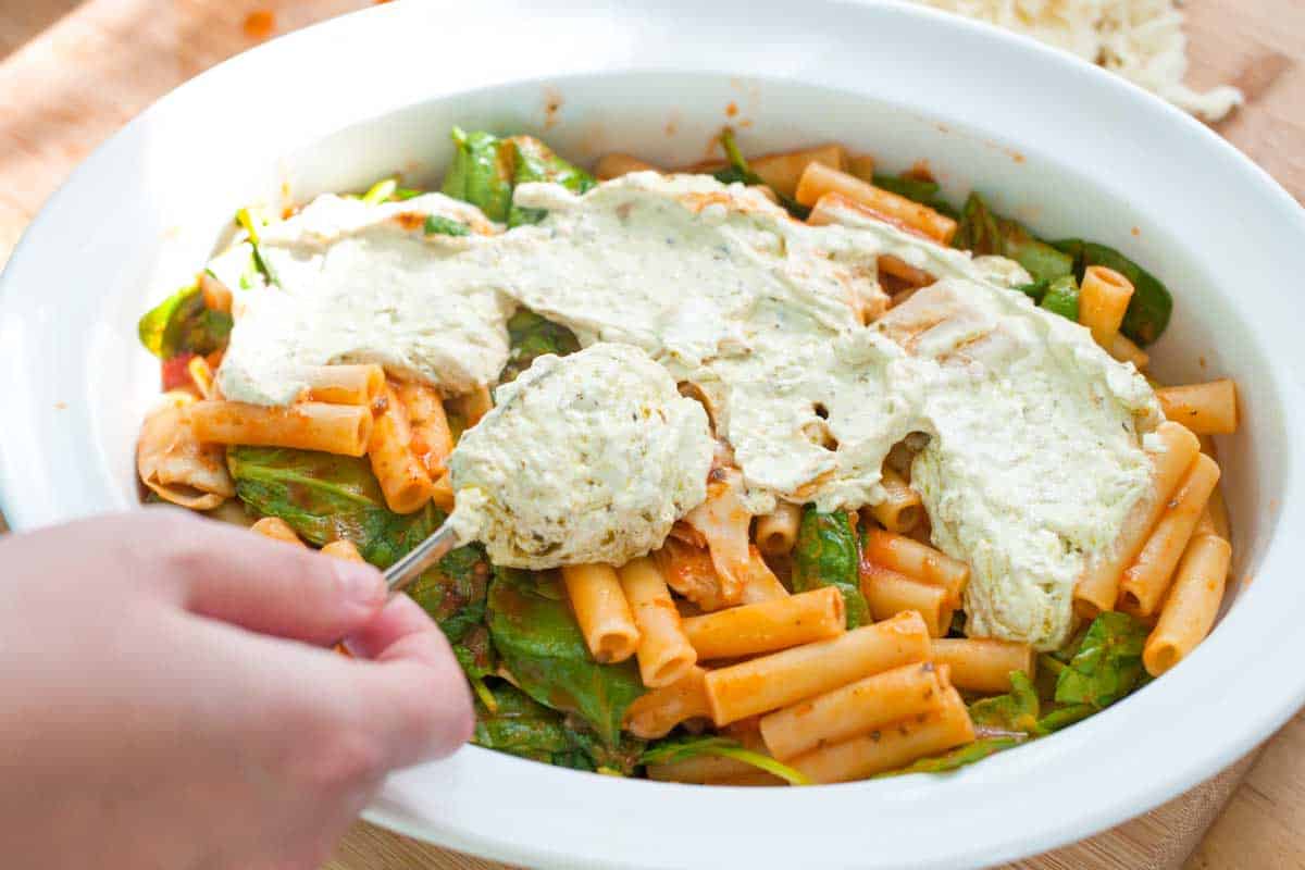 How to Make Spinach Artichoke Baked Ziti: Adding a creamy pesto layer to the middle of the ziti makes this veggie baked ziti extra delicious.