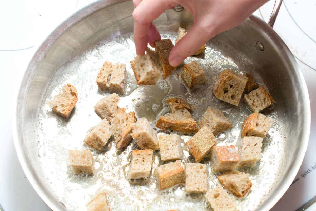 Caesar Salad Recipe with Homemade Croutons Making croutons in a skillet with butter