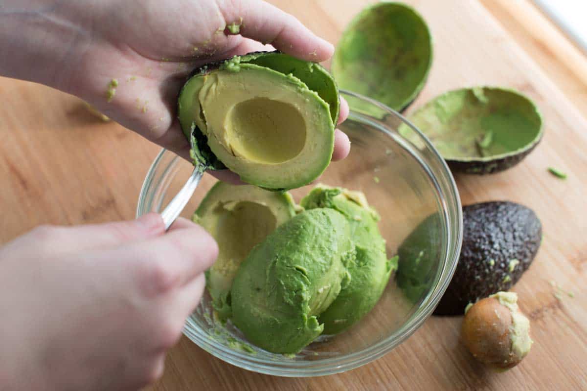 Removing the pit and scooping ripe avocado for guacamole