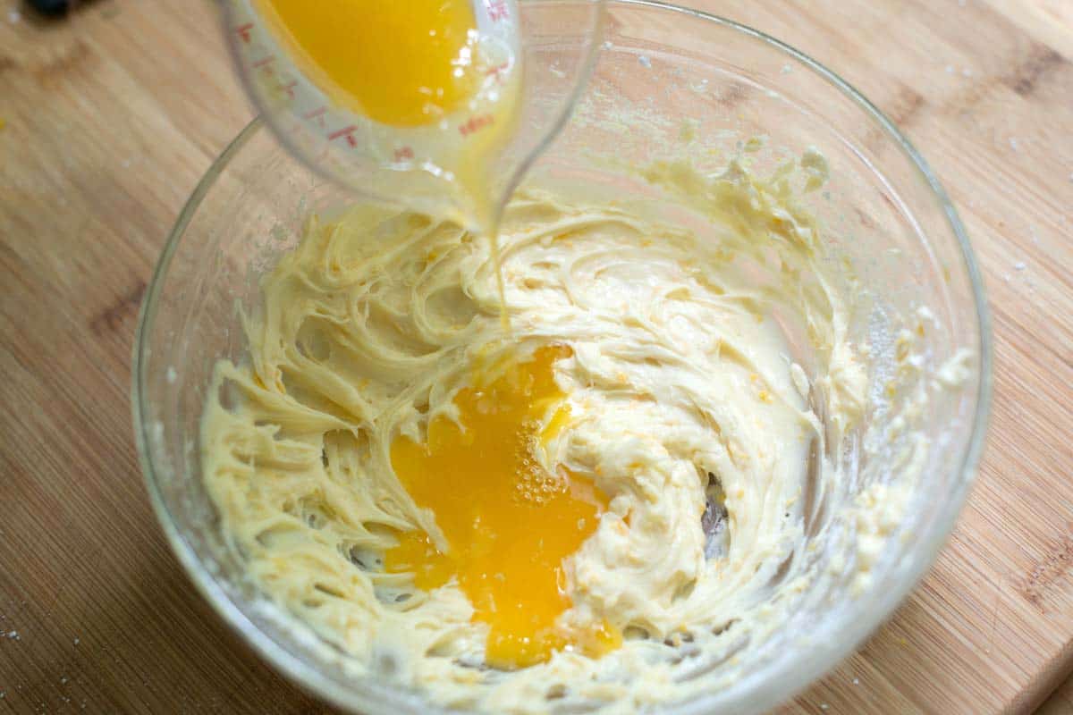 beating cream cheese, vanilla extract, orange zest, powdered sugar, orange juice, and cream together until whipped and creamy