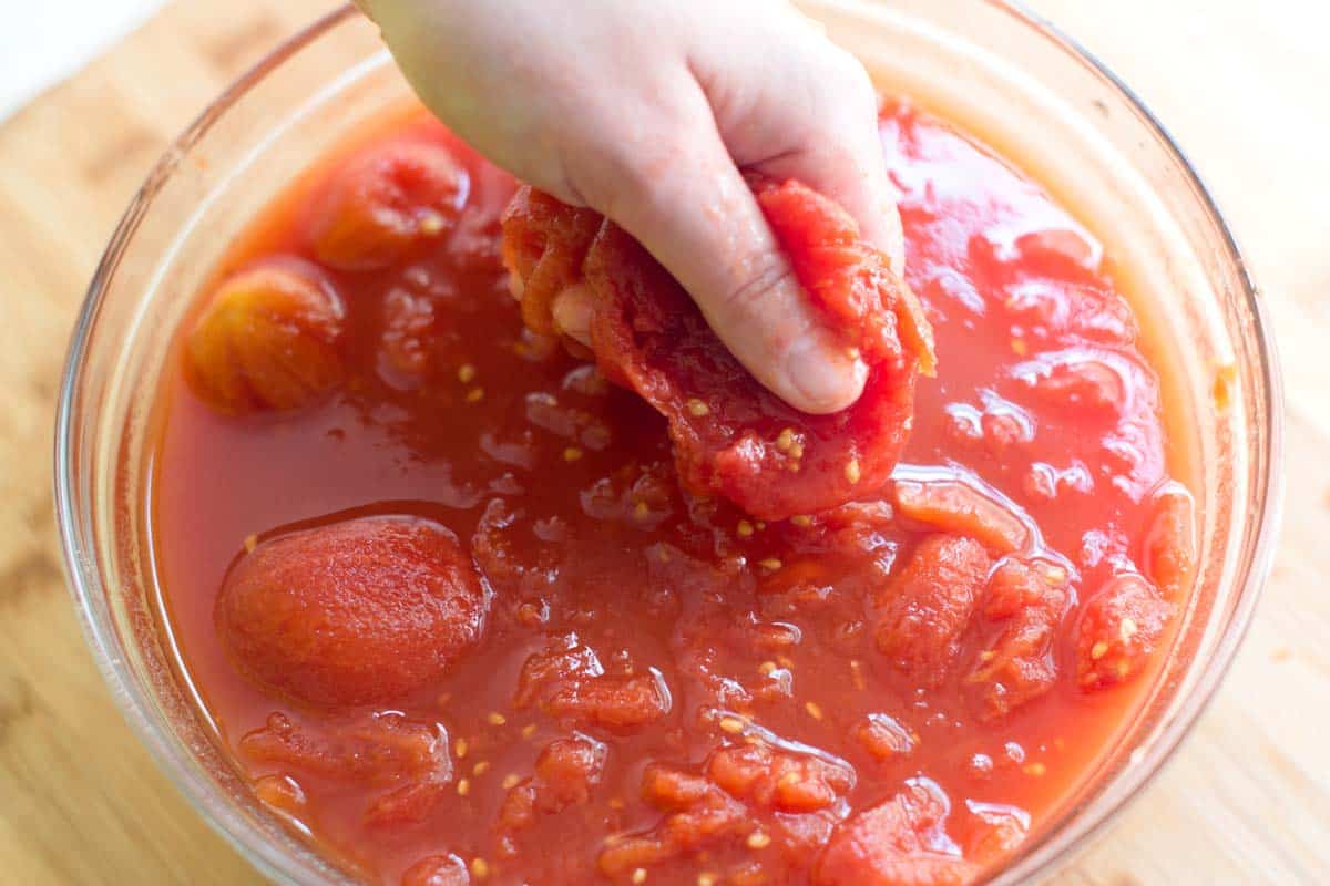 How to Make Marinara Sauce: Crushing whole tomatoes for the sauce