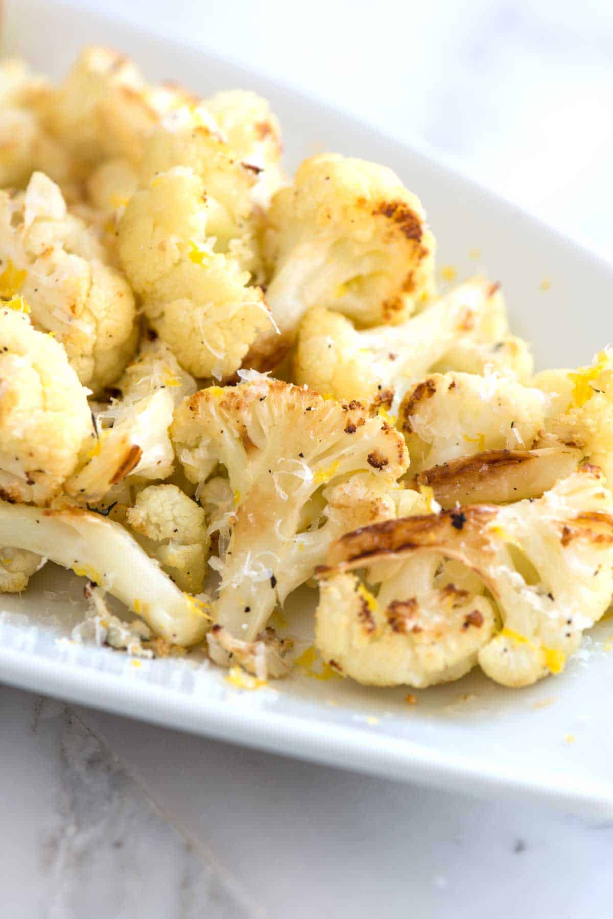 How to Bake Cauliflower in the Oven // Parmesan Lemon roasted cauliflower is one of the tastiest ways to cook cauliflower! See how we turn boring cauliflower into perfectly tender and browned cauliflower.