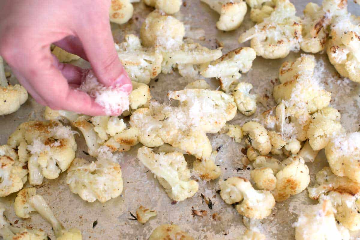 Adding cheese to baked cauliflower // Parmesan Lemon roasted cauliflower is one of the tastiest ways to cook cauliflower! See how we turn boring cauliflower into perfectly tender and browned cauliflower.