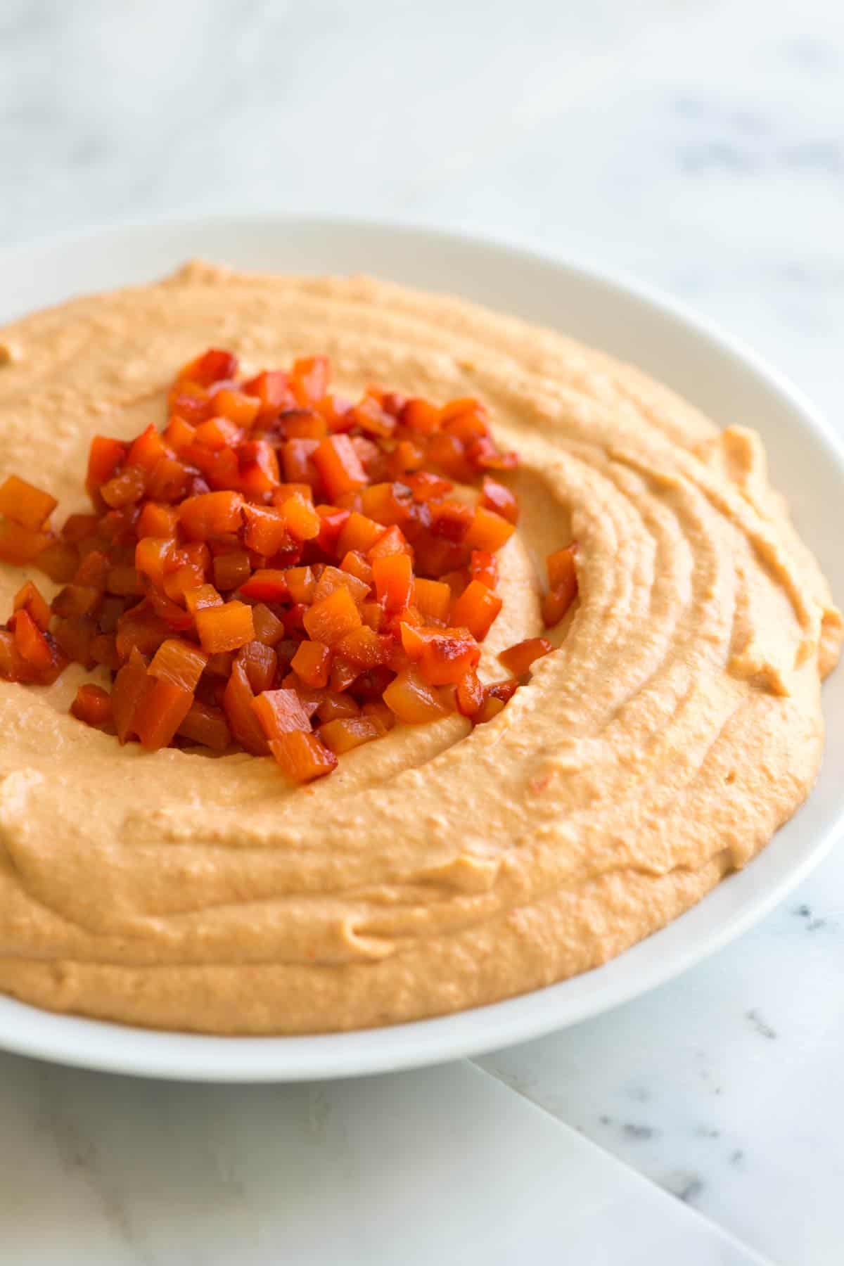 Easy roasted red pepper hummus recipe with sweet red bell peppers, chickpeas, garlic, and tahini.