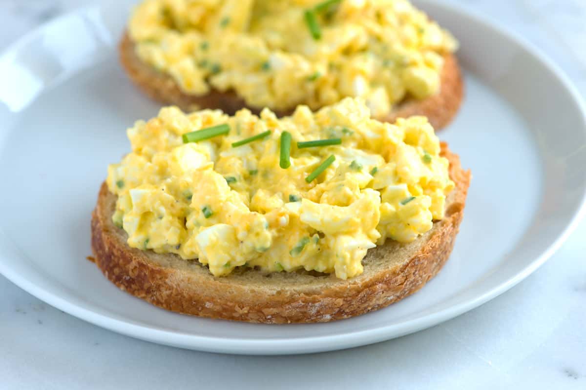 Classic egg salad with visible chunks of egg, diced celery, and a sprinkle of chives.