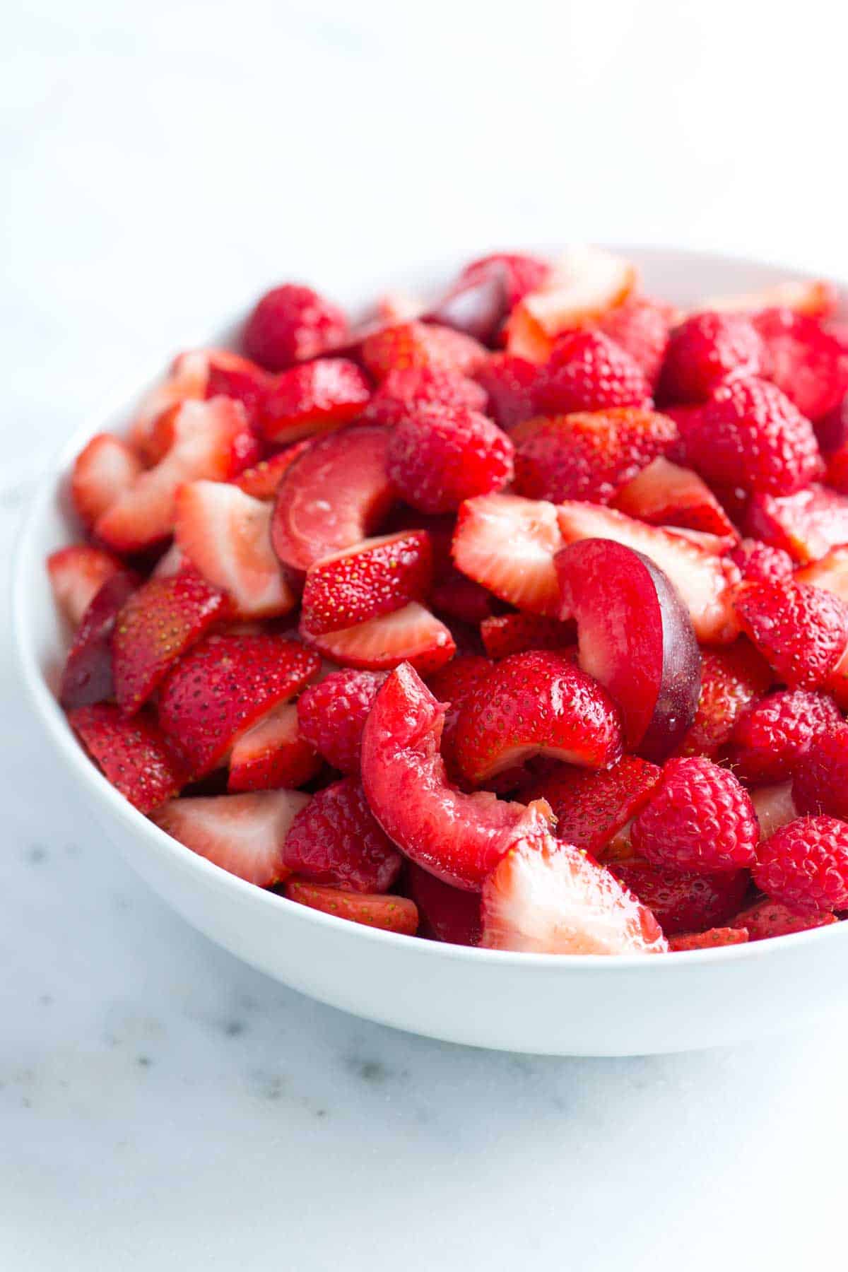 fruit salad with red fruits and an orange dressing