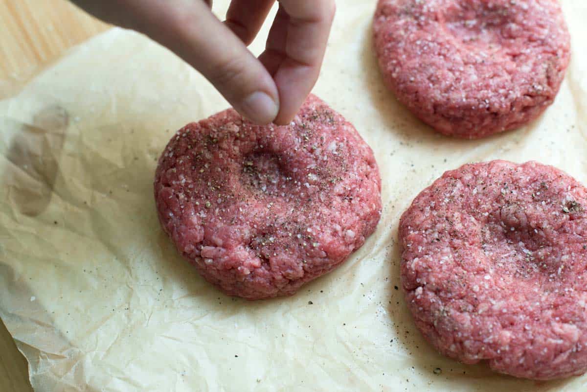 Seasoning the hamburger patties