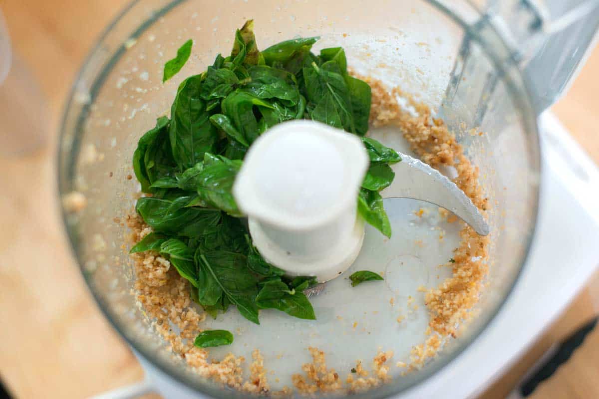How to Make Pesto How to Make Basil Pesto: Basil in a food processor with pine nuts and garlic. (The basil is blanched)