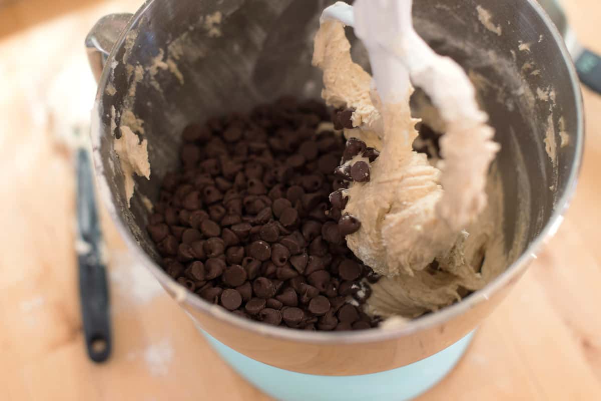 Adding chocolate chips to the cookie batter