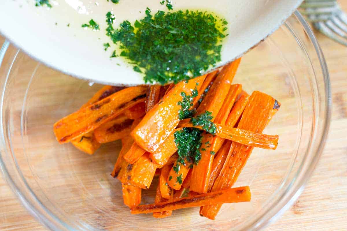 Tossing cooked carrots with garlic butter