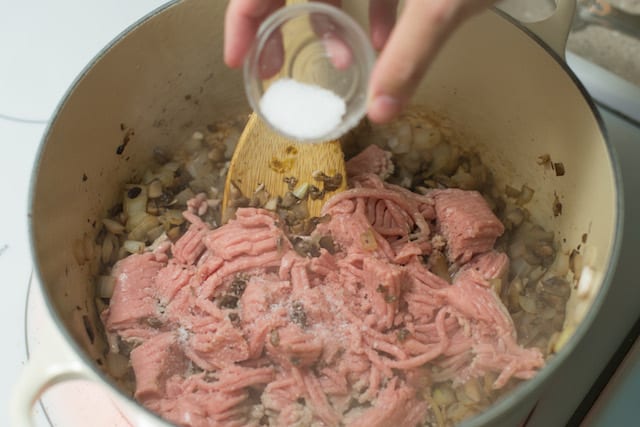 Cooking ground turkey with mushroom, onions, and salt.