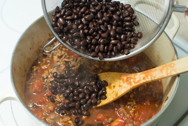 Adding black beans to the turkey in the pot