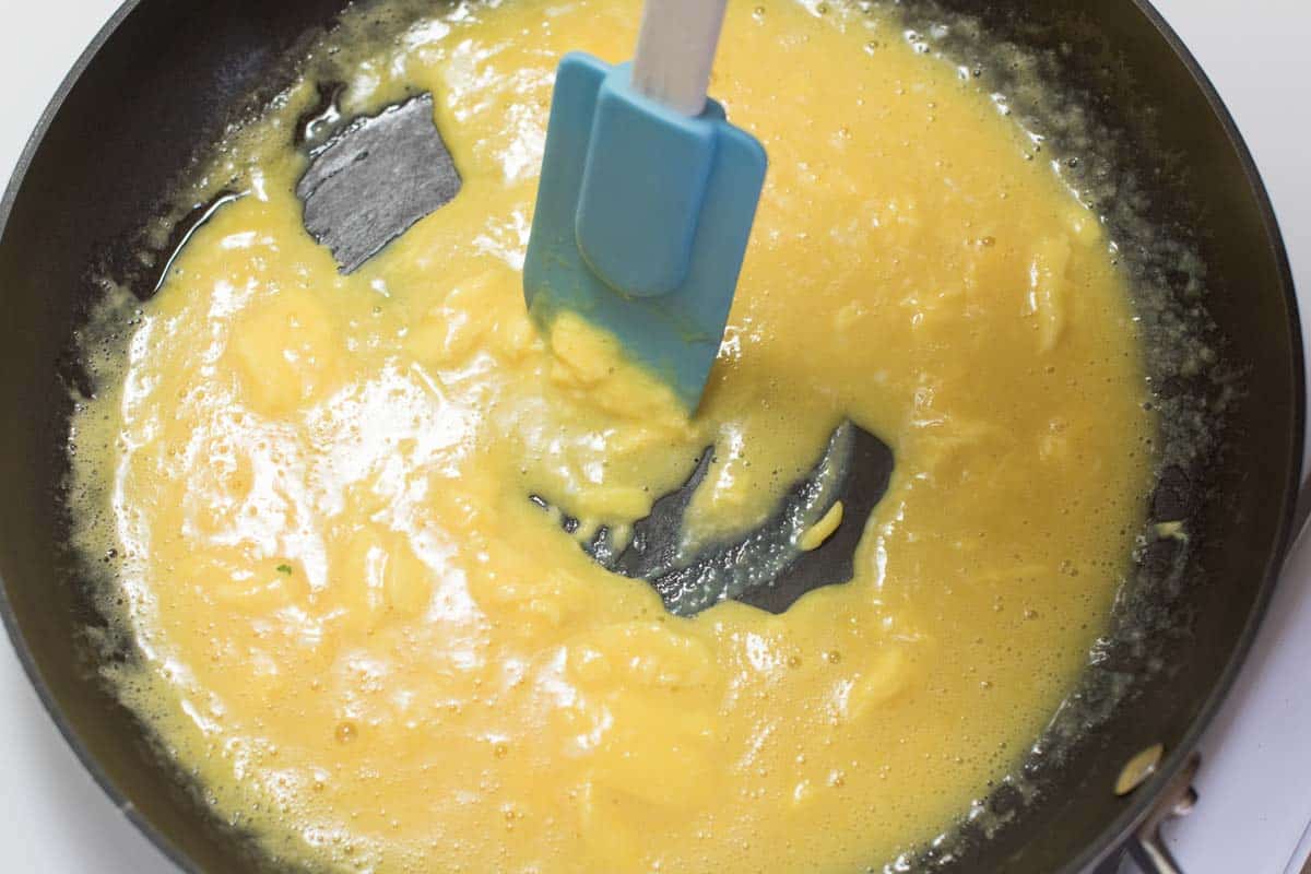 Making scrambled eggs - Cooking the eggs over low heat in a non-stick skillet.