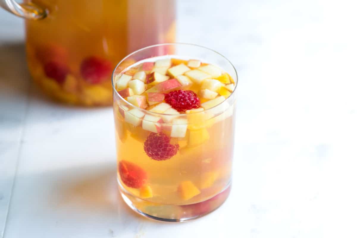 Fruity White Sangria Recipe with Peaches // A fresh and fruity white sangria made with peaches, raspberries, vanilla, Moscato and Riesling. This sangria is almost too good.