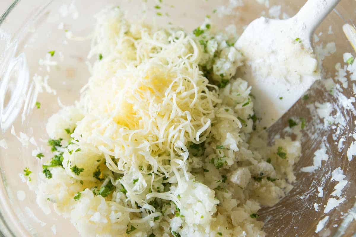 Making Delicious Tater Tots in the Oven How to Make Tater Tots: Stirring in the cheese, parsley, and spices.