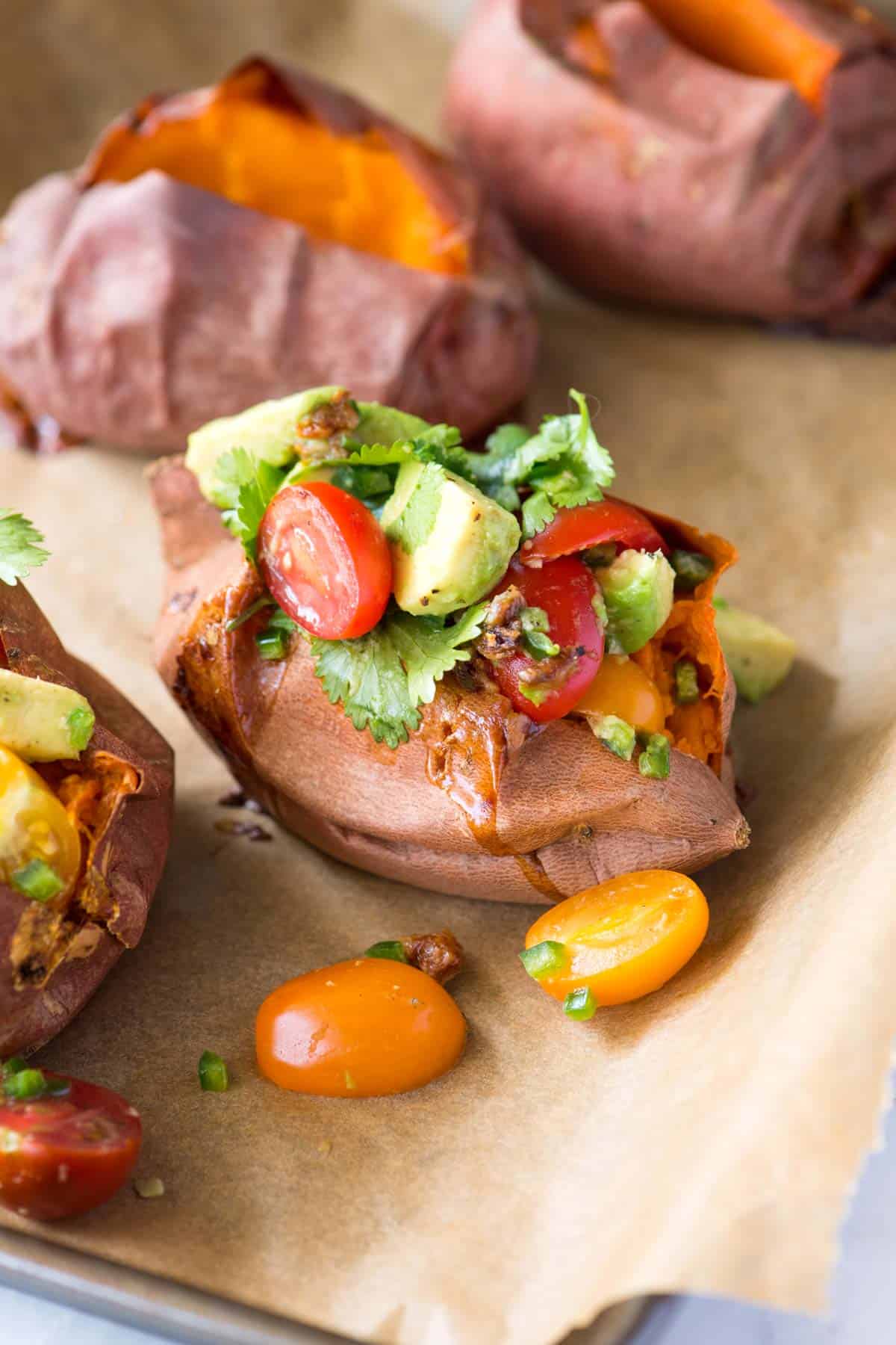 Baked sweet potatoes stuffed with roasted garlic, avocado and tomato salsa (delicious, vegetarian and vegan). 