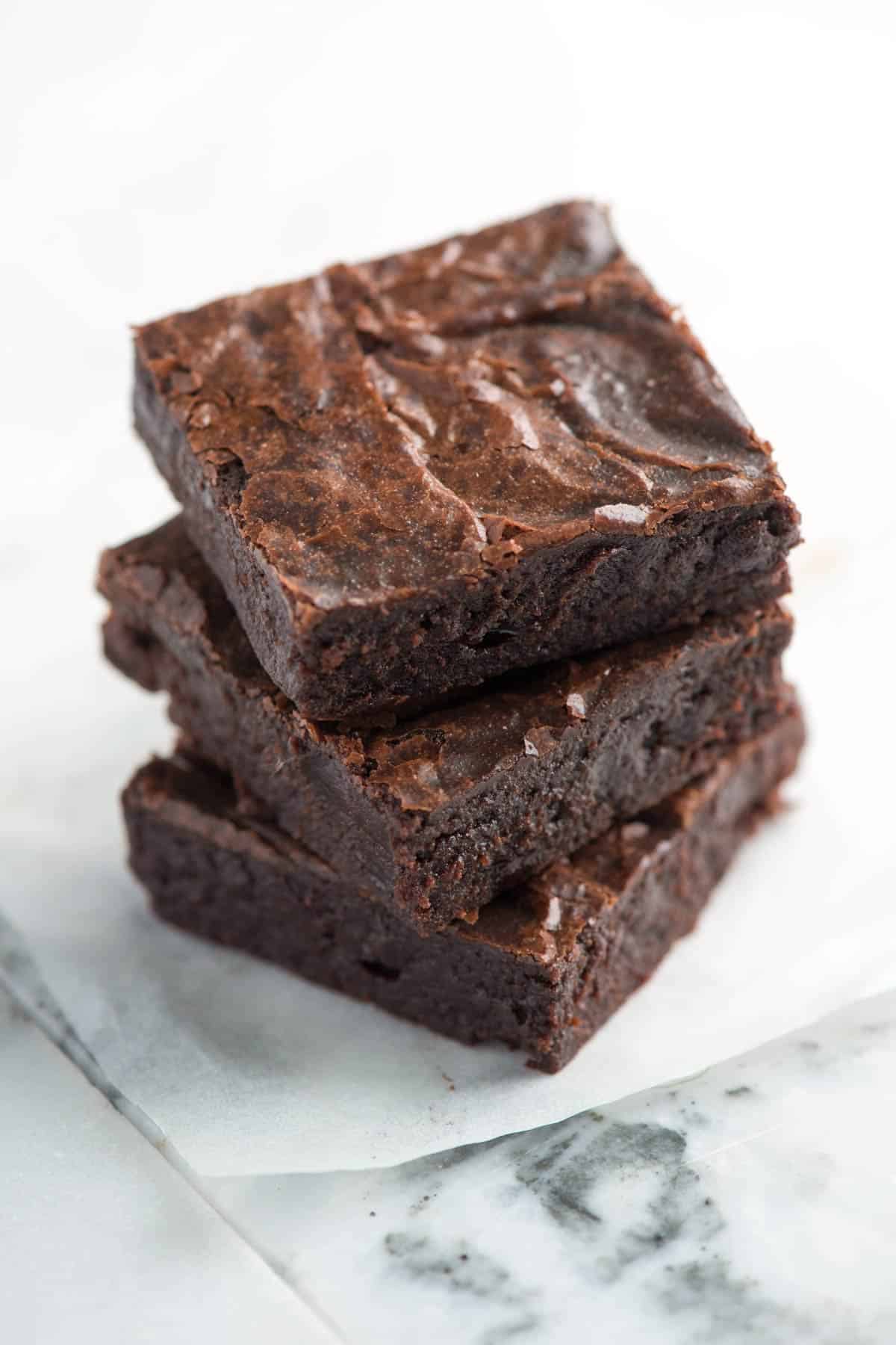 A stack of fudgy brownies with crinkly tops