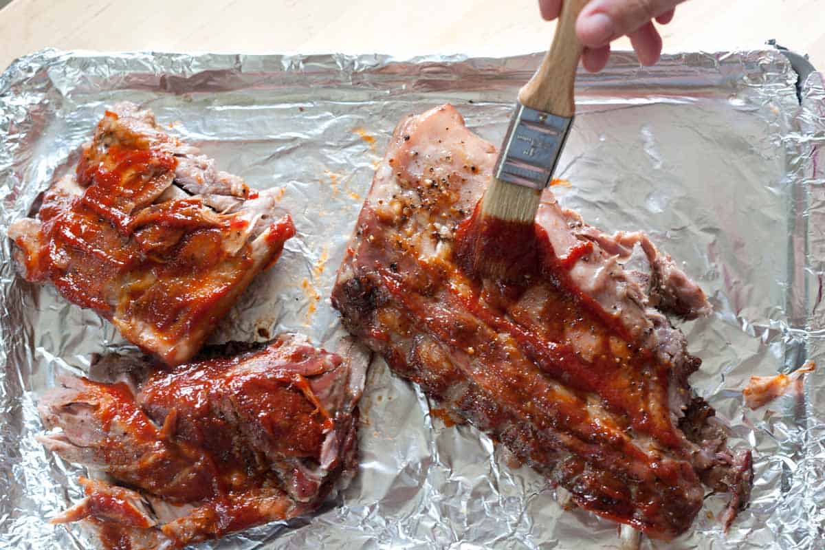 Spread the sauce over the ribs.