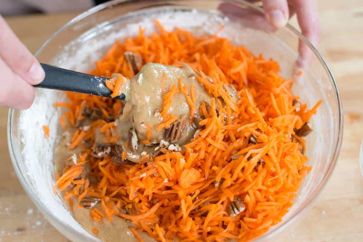 Adding grated carrots to the cake batter.