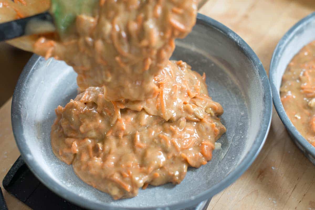 baking carrot cake - pouring carrot cake batter into round cake pans before baking