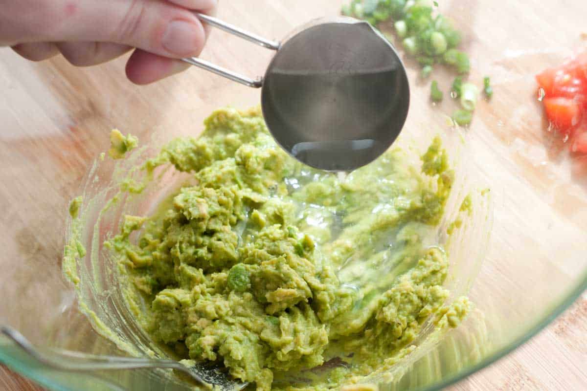 Adding a little hot pasta water to mashed avocado for the pasta sauce