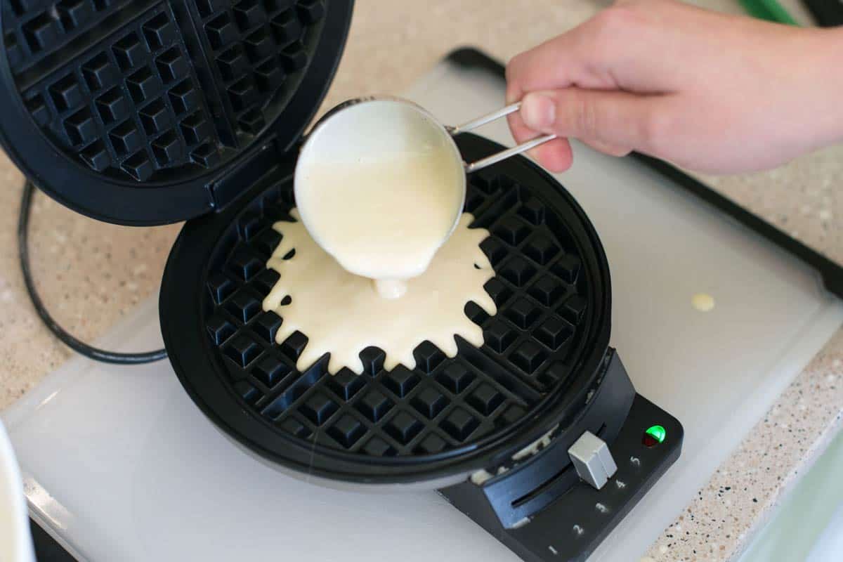 How to Make the Best Waffles: Pouring waffle batter into a regular waffle iron