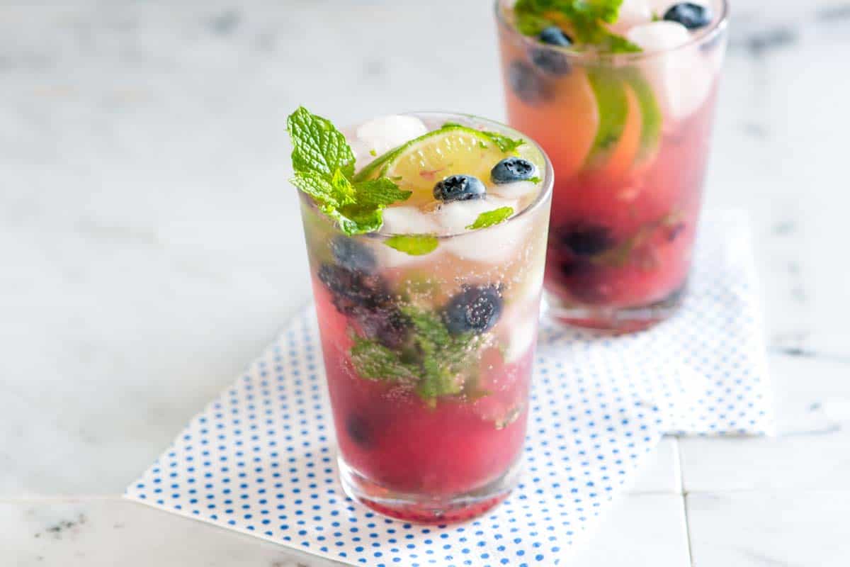 How to make fresh and simple blueberry mojitos with fresh (or frozen) blueberries, white rum, mint, and lime.