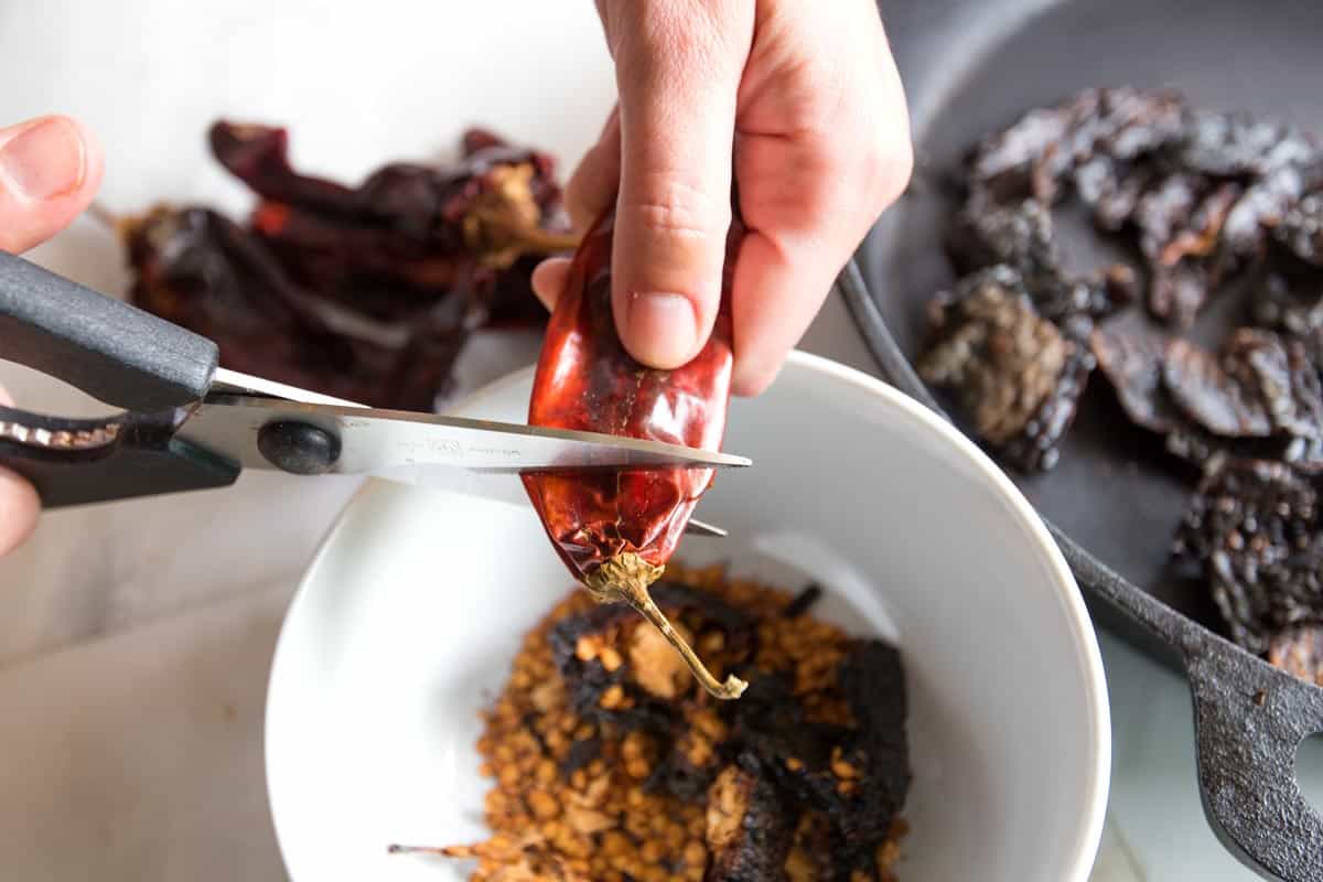 Cutting the stems off dried chili peppers