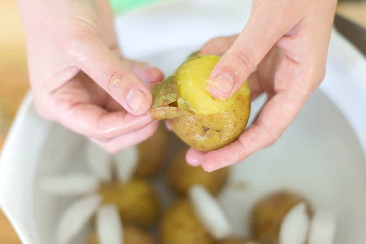 Removing the skins from cooked potatoes for potato salad