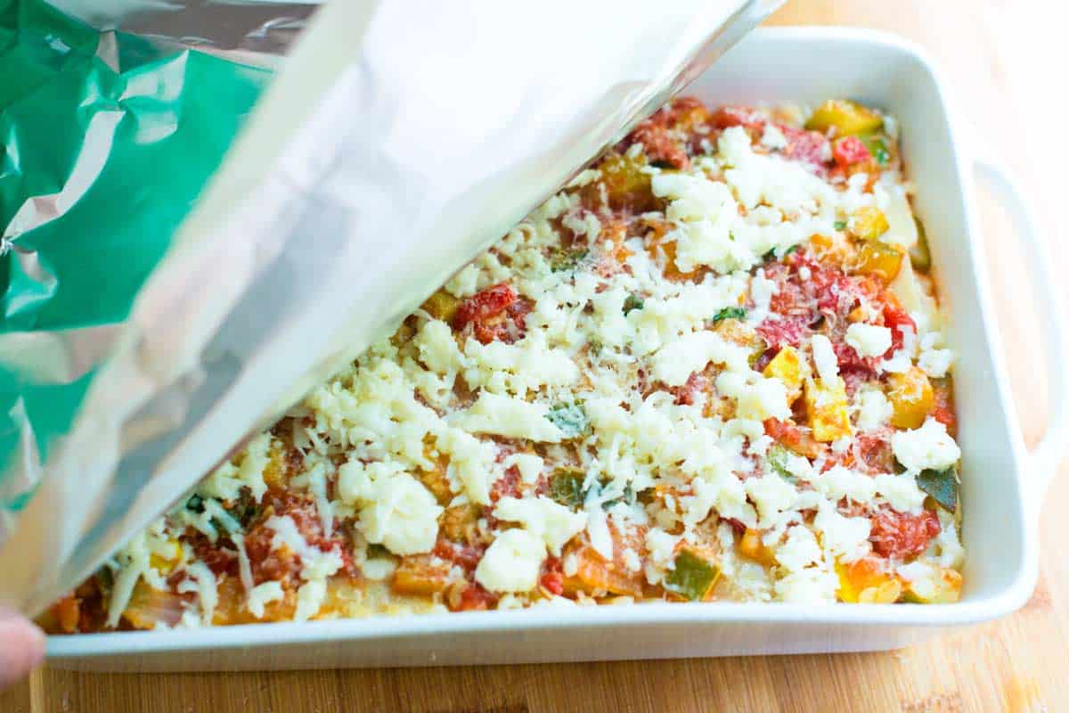 Covering the the veggie lasagna with foil before baking.