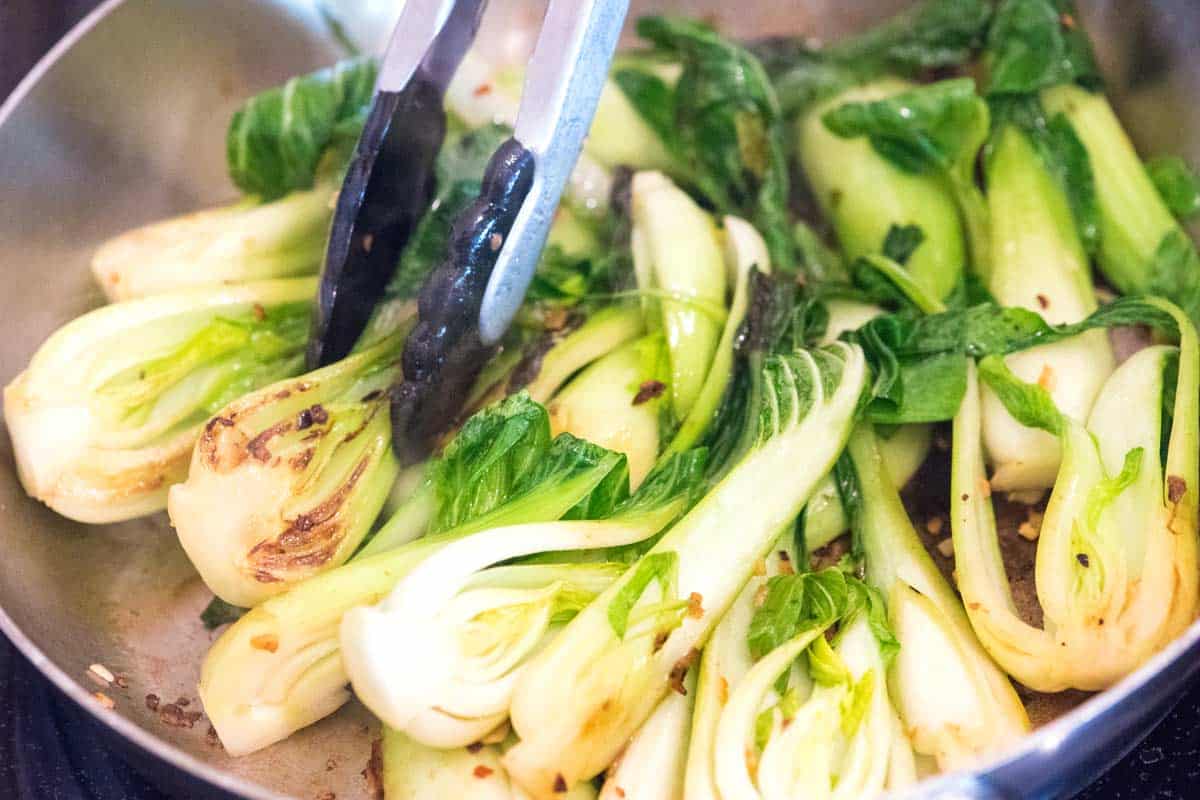 Quickly fry the pak choi with garlic.