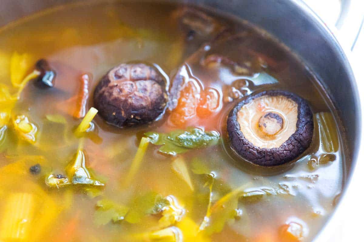 Adding dried mushrooms to make homemade vegetable broth.