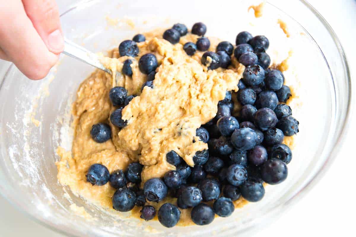 Stirring in the blueberries to the muffin batter