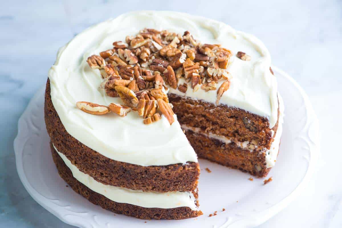 An 8-inch round carrot cake with a slice cut out