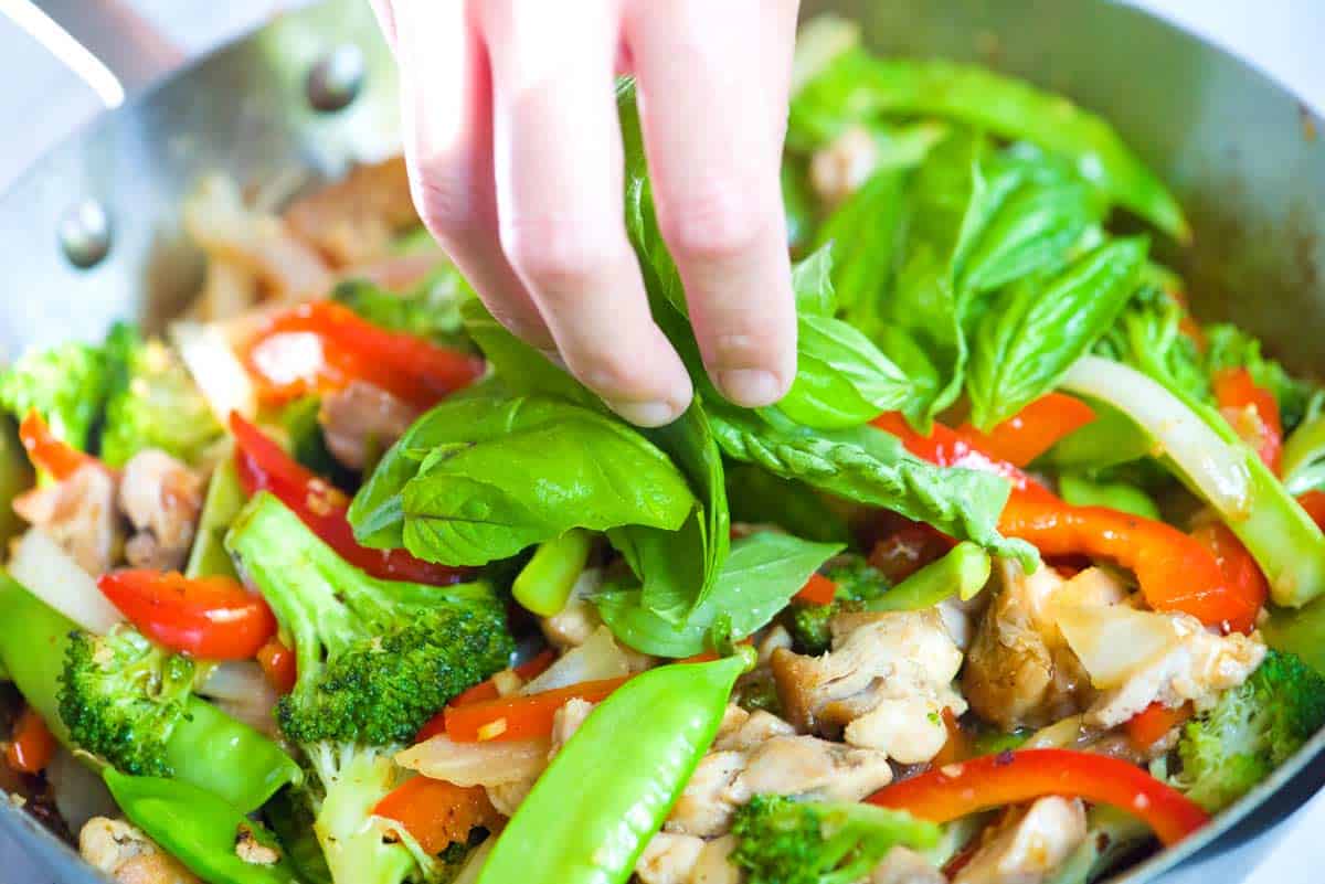 Adding fresh basil to the stir fry