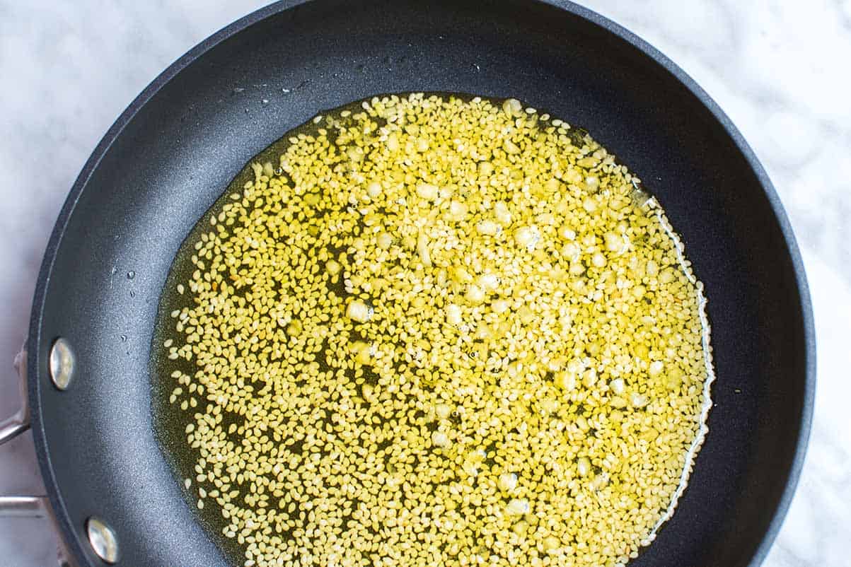 Infusing olive oil with garlic and sesame seeds for the flatbread dough.