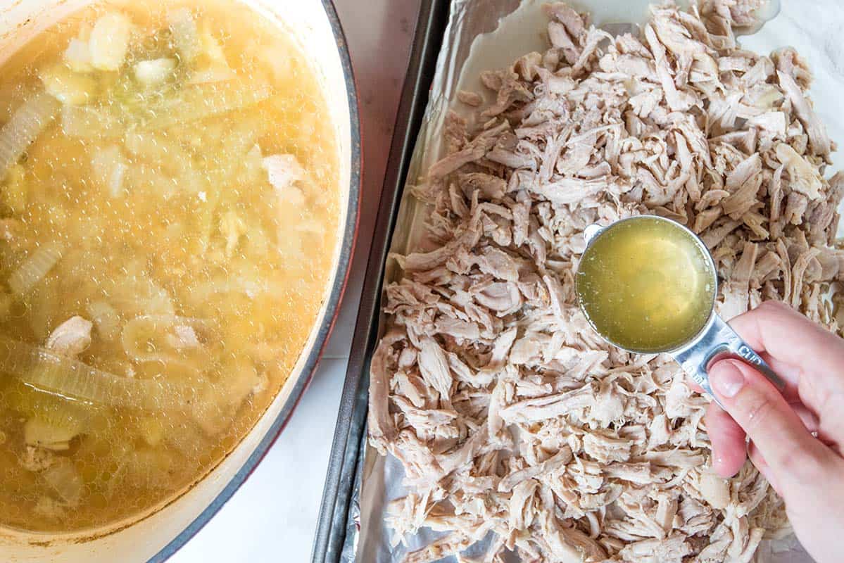 Once the chicken is cooked, remove it from the now incredibly flavorful cooking broth and shred it. 