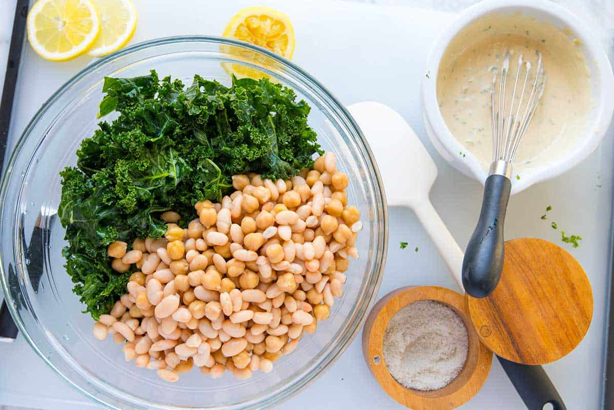 Making a bean salad recipe with kale, tahini and walnuts.