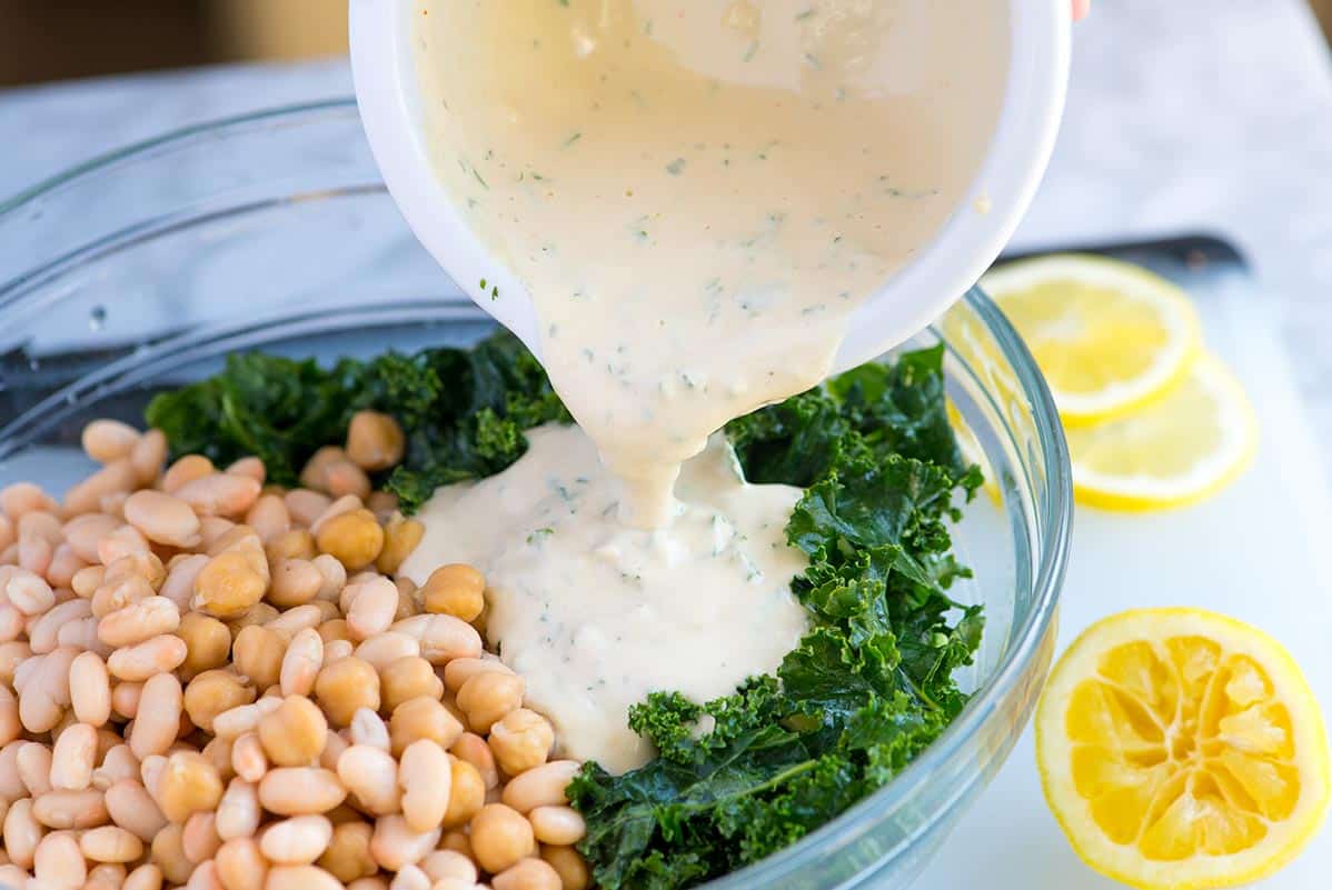 How to Make Kale and White Bean Salad: Adding the tahini dressing.