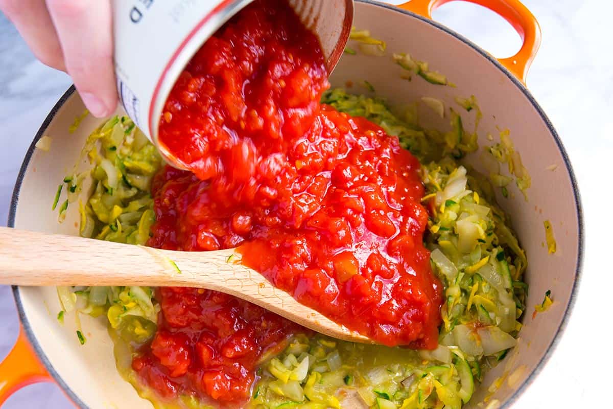 These easy lasagna roll ups with fresh vegetables, a light tomato sauce and cheese are a must make. Make them now or prep and freeze for later. Making a vegetable pasta sauce with zucchini, tomatoes and onion.
